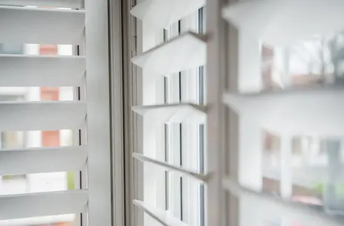TSSUS_210_Slat_CloseUp_In Window_White Shutters.webp